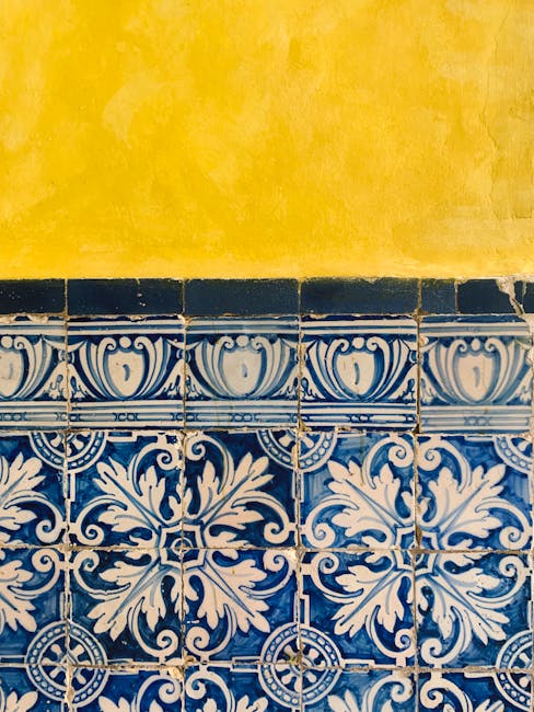 Piastrelle decorate blu e bianche sotto un muro giallo, metafora visiva per il calcolo della radice quadrata e la sua precisione geometrica