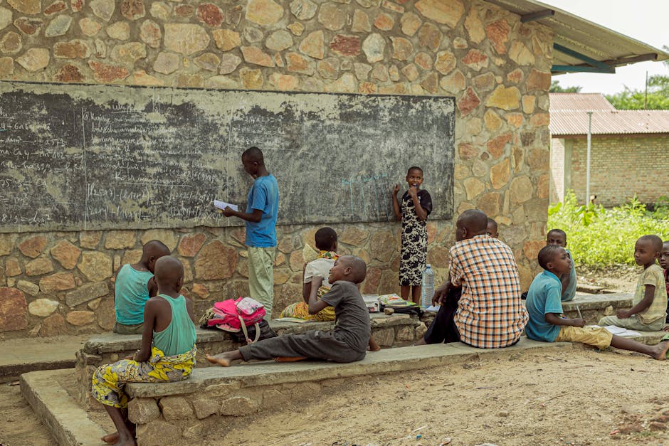 Bambini africani studiano all'aperto su una lavagna, un'immagine che evoca l'importanza del sostegno scolastico e dell'inclusione per tutti gli studenti.