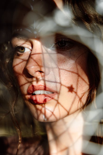 Volto femminile in ombra: metafora visiva della sorveglianza in 1984 di Orwell, riflettendo il controllo e la perdita di identità.