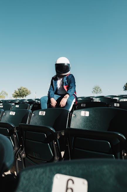 Figura enigmatica con casco da astronauta seduta tra le file di sedili, simbolo di nuove prospettive cosmiche e scoperte uniche.