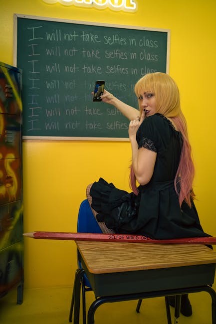 Ragazza seduta su banco scolastico scatta selfie davanti a lavagna con scritta 'Non farò selfie in classe', concetto di personalizzazione dell'apprendimento
