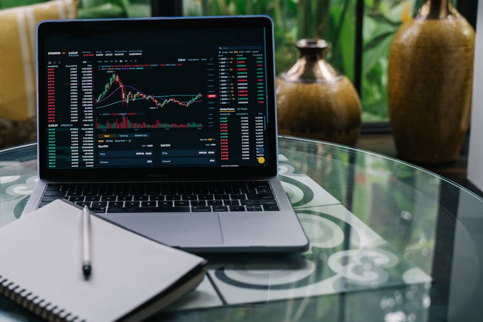 Piattaforme di Trading: Investire in sicurezza con grafici online Laptop con grafico di trading online e notebook per investire in sicurezza sulle piattaforme di trading finanziario.
