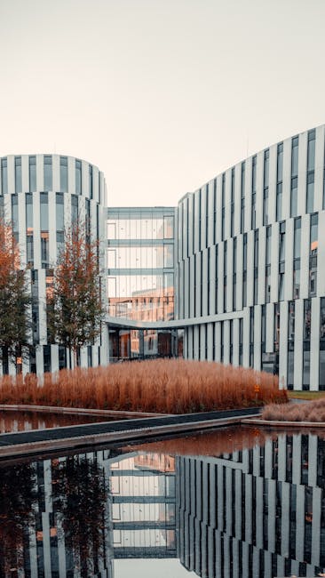 Edificio moderno con riflessi sull'acqua, esempio di architettura innovativa per lo sviluppo professionale sostenibile.