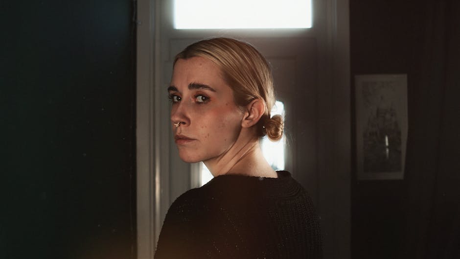 Donna bionda che si volta indietro, sguardo intenso e riflessivo, evocando la ricerca della memoria perduta in Proust