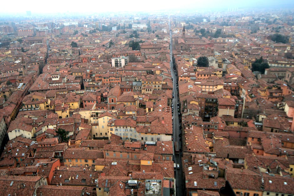 Panoramica aerea di Bologna con tetti rossi, studenti organizzano gita alternativa a Parigi, viaggio autogestito a Bologna