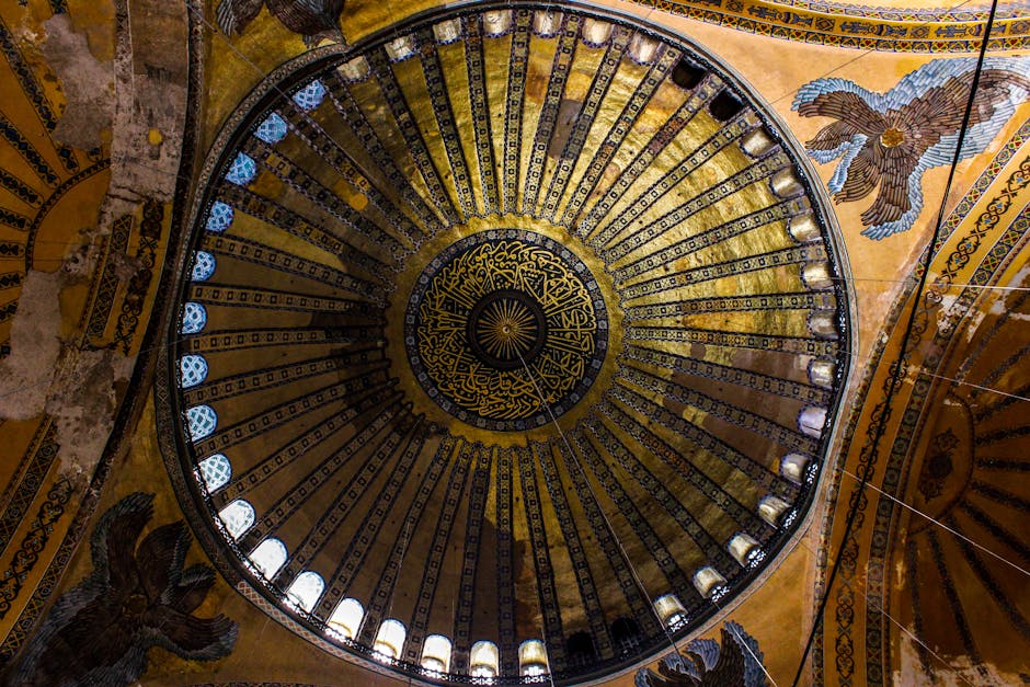 Interno della cupola dorata di una basilica con mosaici e decorazioni artistiche, simbolo di spiritualità e arte sacra.