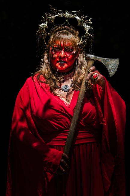 Maria la Sanguinaria: Regina di Terrore e Potere Ritratto di donna vestita di rosso con trucco rosso e corona, che evoca Maria la Sanguinaria e il terrore del potere regale.