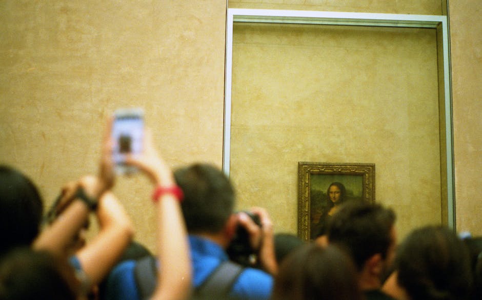 Turisti fotografano la Gioconda al Louvre: l'eredità di Leonardo da Vinci nel mondo dell'arte e della cultura.