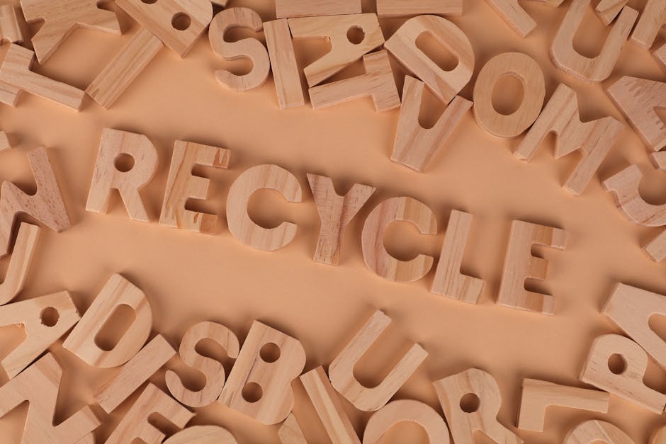 Lettere di legno che compongono la parola Recycle, simbolo di design sostenibile e responsabilità ambientale per il futuro del pianeta.