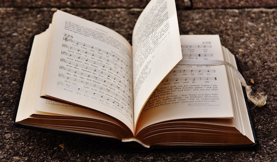 Libro aperto con spartiti musicali e testo in tedesco, metafora di funzioni strumentali e staff che guidano l'organizzazione.