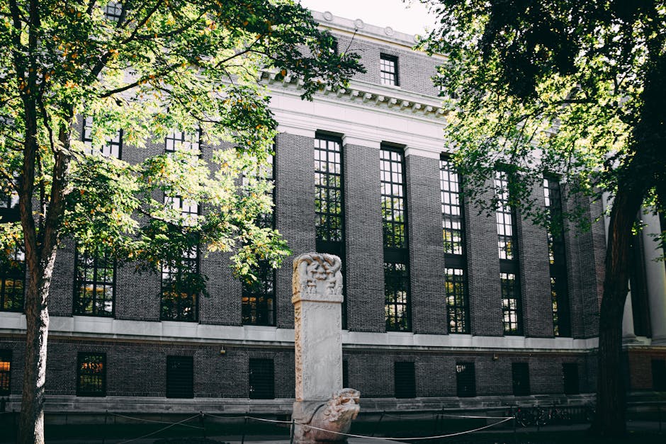 Edificio di Harvard con monumento, simbolo della nuova politica sui voti alti e la meritocrazia nell'istruzione superiore americana.