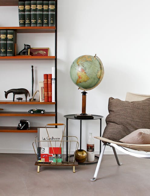 Angoli adiacenti in design: libreria vintage, mappamondo e poltrona moderna creano un ambiente armonioso e funzionale.