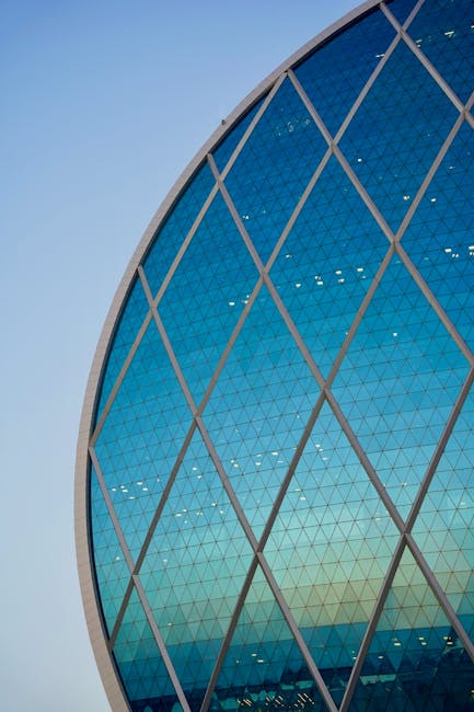 Edificio circolare con facciata a losanghe di vetro blu, esempio di geometria applicata all'architettura moderna.