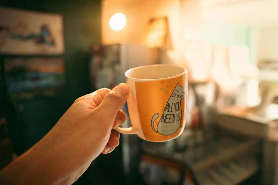 Pausa caffè per docenti durante la visita fiscale: tazza con gatto e scritta motivazionale, momento di relax e attesa della visita medica