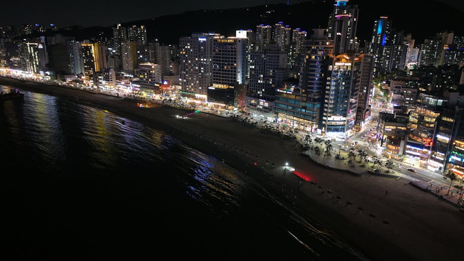Paesaggio notturno urbano con spiaggia illuminata, simbolo della vulnerabilità online e dei pericoli nascosti per la Generazione Z