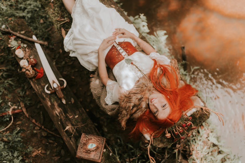 La Magia dell'Epica Greca: Donna con spada e libro Giovane donna con capelli rossi, vestito bianco e corpetto sdraiata su un tronco con spada e libro magico, evocando l'epica greca.