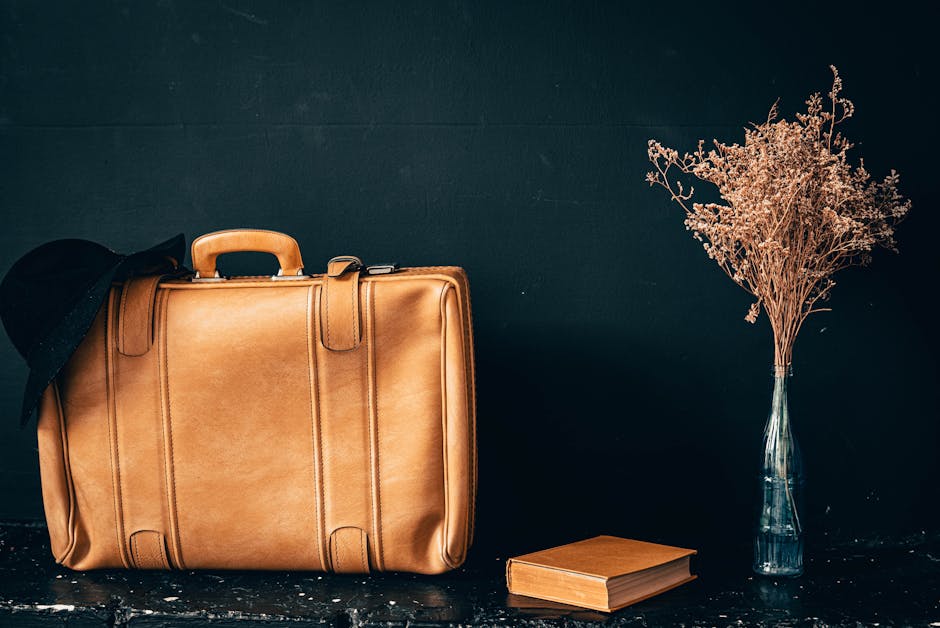Natura morta con valigia vintage libro e fiori secchi evocativa di viaggi letterari e capolavori senza tempo