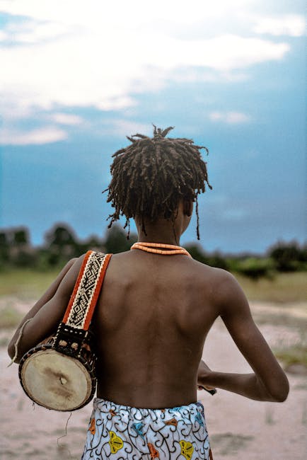 Bambino africano con tamburo: esplorando il mondo sonoro nella prima infanzia attraverso la musica e il ritmo tradizionale.