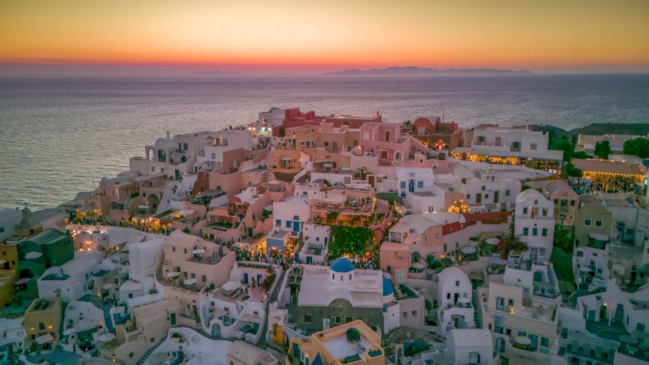 Vista aerea di Santorini al tramonto, simbolo dell'epica greca e dei suoi valori immortali, con case bianche e mare Egeo
