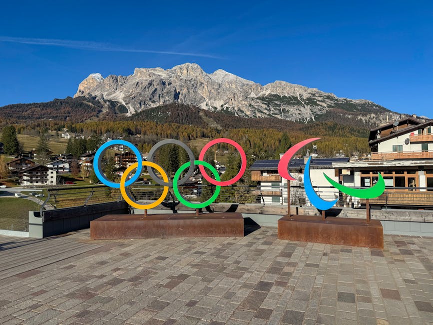 Anelli olimpici e simbolo paralimpico a Cortina d'Ampezzo, sfondo Dolomiti, celebrazione Milano-Cortina 2026 e successo atleti italiani