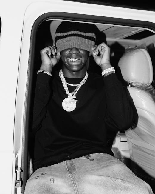 Uomo sorridente con cappello sugli occhi e gioielli, simbolo di espressione e liberazione emotiva nella musicoterapia.