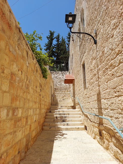 Scalinata in pietra tra mura antiche a Gerusalemme, illuminata da un lampione, evocativa delle epoche storiche e delle dinastie passate.