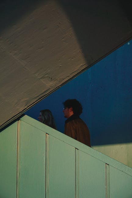 Persone in piedi vicino a una struttura angolare, concetto di angoli adiacenti a un lato in geometria e architettura.