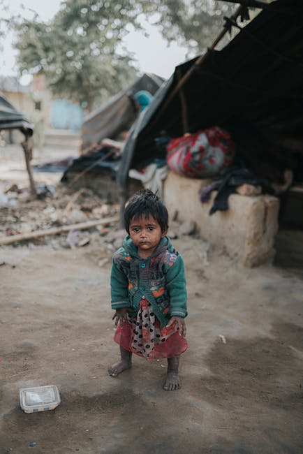 Bambina in condizioni di povertà estrema, riflesso delle disuguaglianze globali e impatto sulla vita quotidiana di un miliardo di persone.