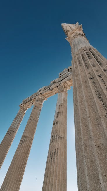 Antiche colonne romane contro cielo azzurro, evocazione del mondo classico e dell'eredità di Virgilio nella letteratura e nella storia.