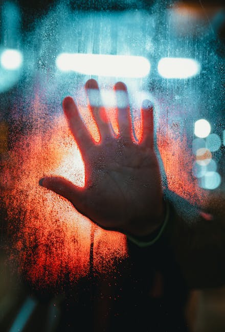 Mano su vetro appannato che simboleggia la diffusione dell'influenza K nonostante la chiusura delle scuole, avvertimento di Burioni.