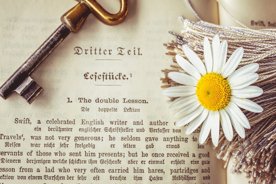 Chiave antica su libro aperto con testo in tedesco e inglese e una margherita, simbolo della poesia classica di Virgilio.