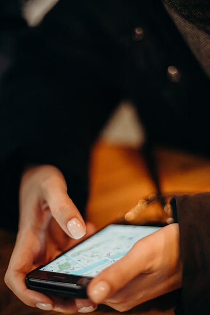 Mani femminili che utilizzano app di navigazione su smartphone, esempio di tecnologie dell'informazione e comunicazione