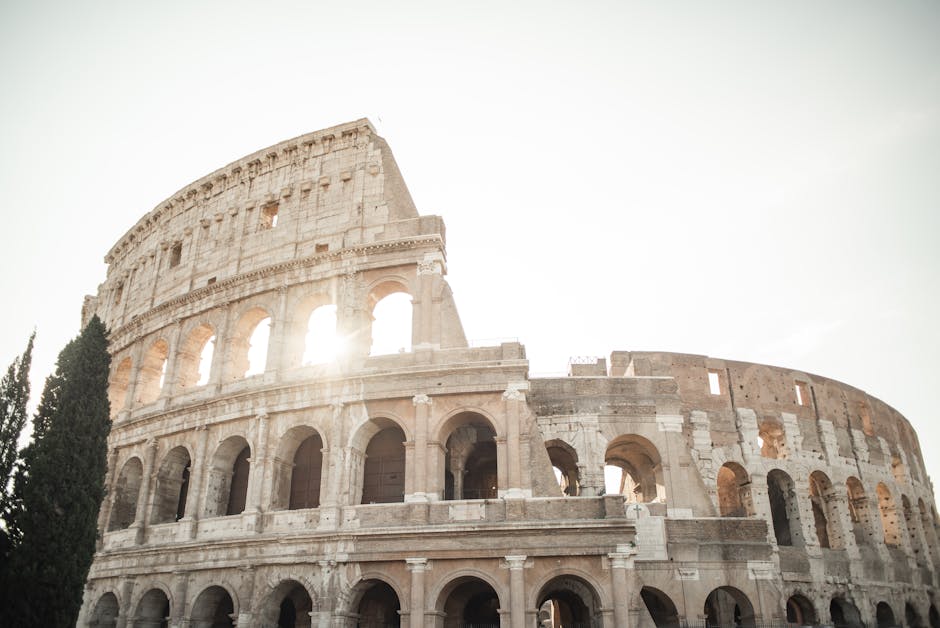 Colosseo di Roma illuminato dal sole, simbolo dell'eredità romana e degli imperatori che hanno segnato la sua storia.
