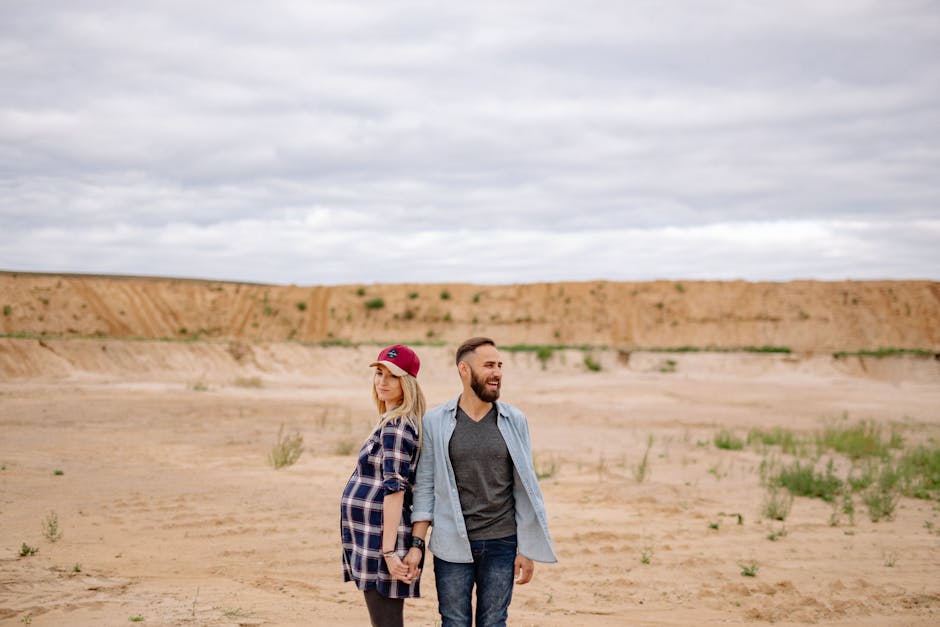 Donna incinta e uomo schiena contro schiena nel deserto, simbolo di crescita e saggezza nell'articolo sulla traduzione unica.