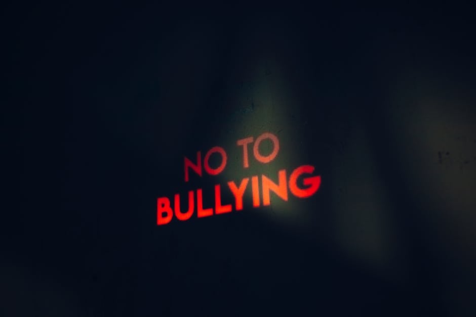 Scritta luminosa rossa 'No to Bullying' su sfondo scuro, simbolo della lotta al cyberbullismo nelle scuole e progetti di prevenzione.