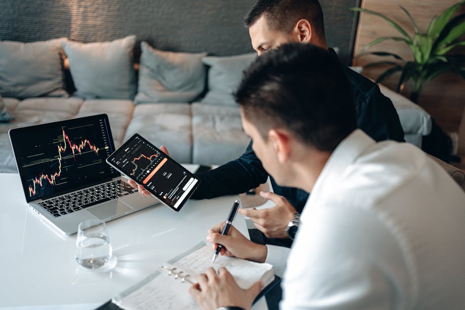 Analisi dati ITS: due professionisti esaminano grafici su laptop e tablet, prendendo appunti per la crescita nel Sud Italia