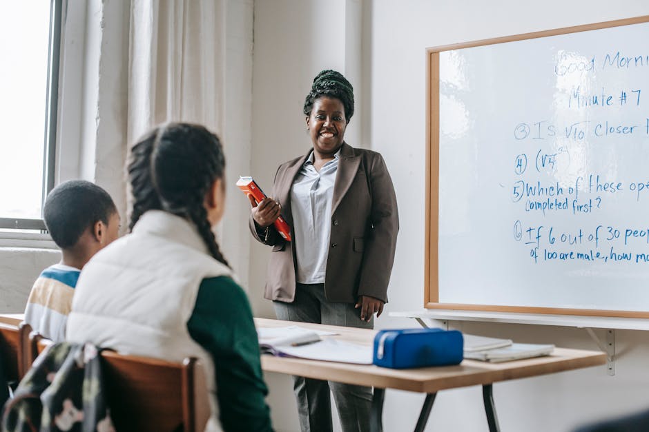 Insegnante sorridente in aula con studenti, formazione INDIRE per la lettura a scuola, focus su tutti i docenti e non solo quelli di lettere.