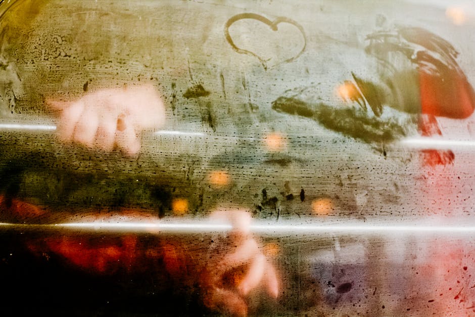 Emozioni musicali: un cuore disegnato Mani che disegnano un cuore su un vetro appannato, metafora di emozioni e creatività nella formazione musicale
