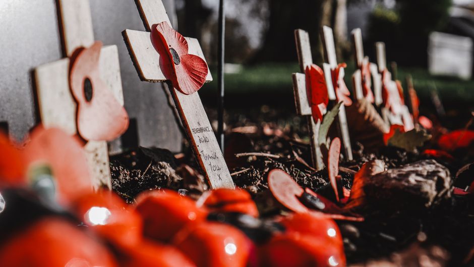 Croci di legno con papaveri rossi per il Giorno del Ricordo, simbolo di memoria e gratitudine per i caduti.