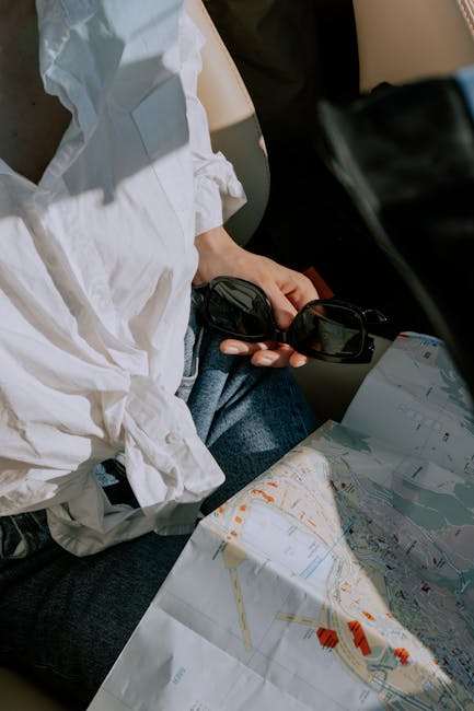 Pianificazione viaggio in auto con mappa e occhiali da sole. Assicurazione auto per una guida sicura e senza pensieri.