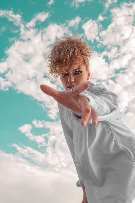 Donna con mano tesa verso l'alto, cielo nuvoloso sullo sfondo, simbolo di apprezzamento e valorizzazione degli altri.