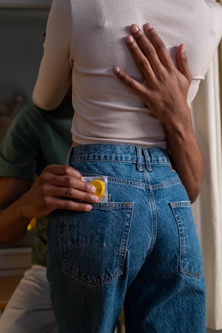 Coppia abbracciata con preservativo nella tasca dei jeans, implicazioni per l'educazione sessuale e il consenso familiare.