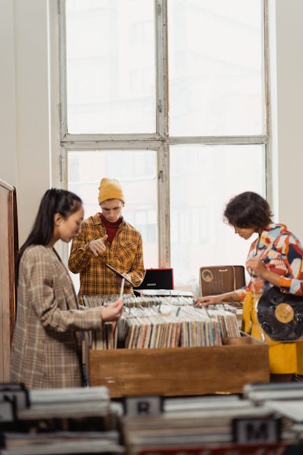 Amici che esplorano dischi in vinile in un negozio vintage, un'attività musicale unica e divertente per esperienze condivise.