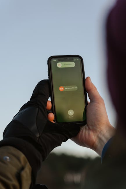 Smartphone con avviso SOS attivo durante allerta meteo in Campania, scuole chiuse per maltempo e rischio idrogeologico.