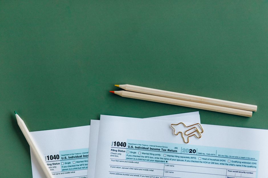 Documenti fiscali 1040 con matite e graffetta a forma di cavallo, simbolo della flat tax per docenti privati dal 2027