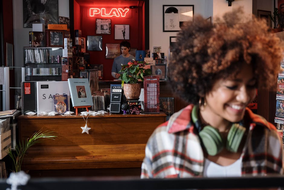 Shopping assistito: scopri il tuo negozio di dischi ideale Assistente acquisti in negozio di dischi: donna sorridente con cuffie, vinili e atmosfera vintage per un'esperienza di shopping unica.