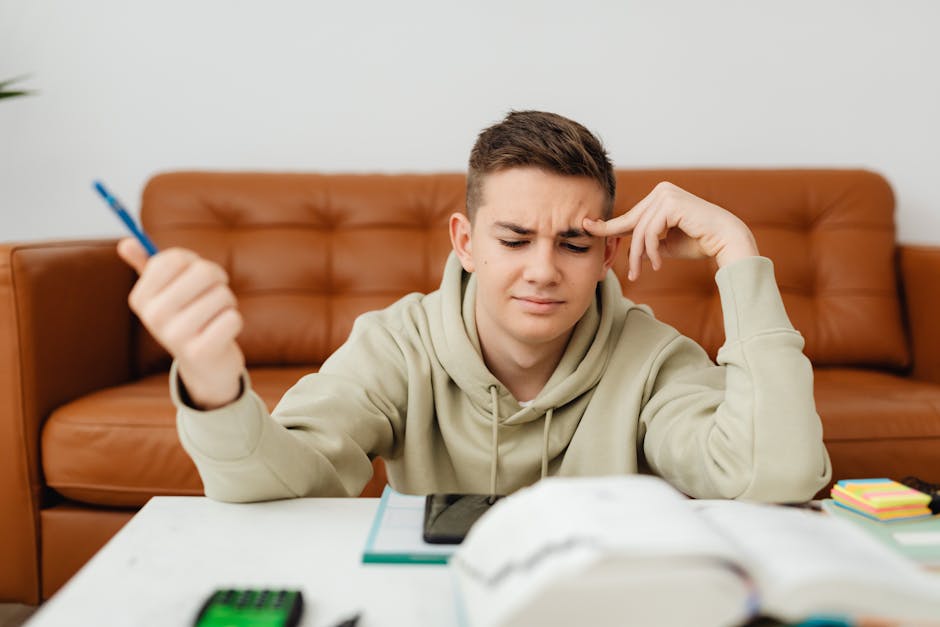 Sfide dell'apprendimento: Intelligenza Artificiale e Scuola Studente pensieroso con penna in mano di fronte a libri e smartphone, riflettendo sulle sfide dell'apprendimento nell'era digitale