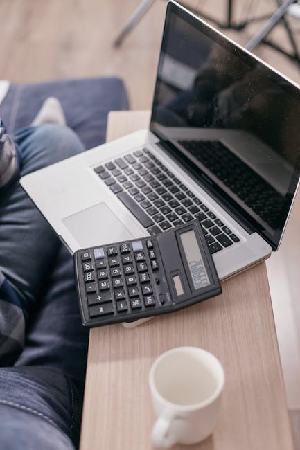 Calcolatrice su laptop per calcolo volume, tazza di caffè, guida pratica e formule essenziali per studenti e professionisti.
