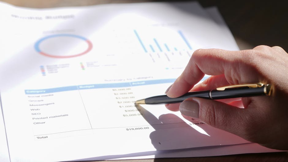 Analisi del bilancio aziendale con grafici e penna, focus sulla gestione finanziaria e contabilità per una corretta pianificazione aziendale