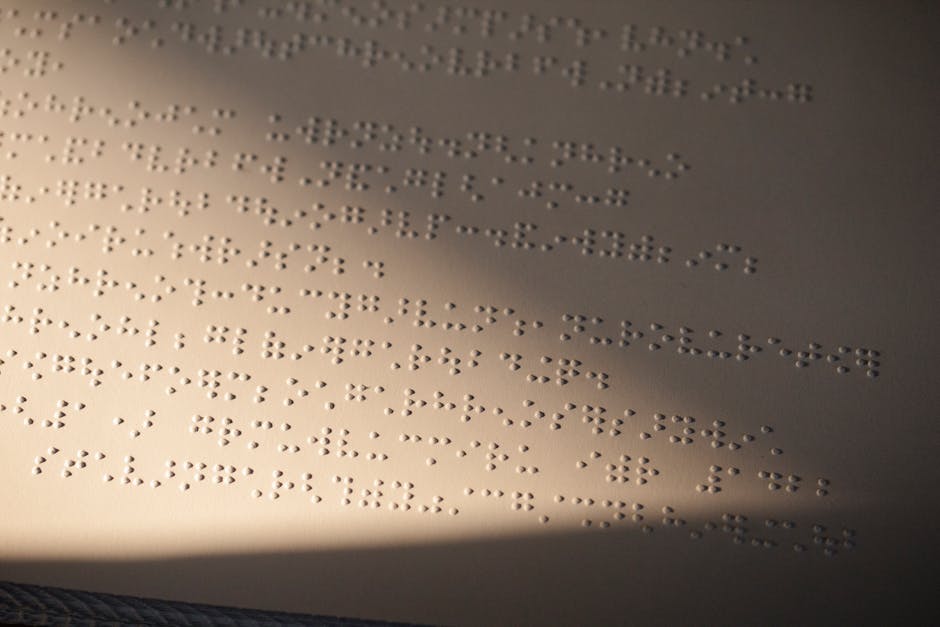 Testo in braille illuminato, esempio di scrittura inclusiva e accessibilità per persone con disabilità visiva. Comunicazione tattile.